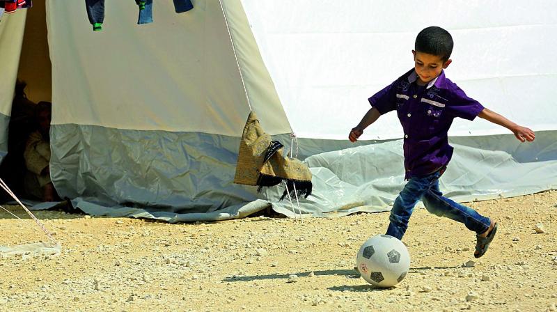 A Syrian boy kicks a ball in a camp for displaced Syrians from the former rebel bastion of Douma, in al-Bil, east of the rebel-held town of Azaz in northern Syria on Friday. 	 (Photo:AFP)