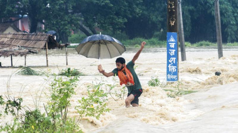 Families perched on trees with young children overnight as flood waters swept away homes in a village in southern district of Chitwan, local media reported. (Photo: AP)