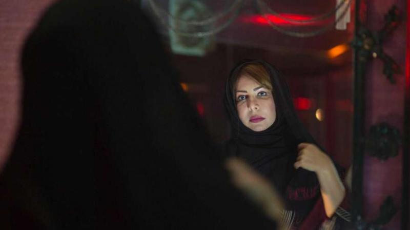 Saudi womens rights activist Souad al-Shammary puts on a head scarf in Jiddah, Saudi Arabia. (Photo: AP)