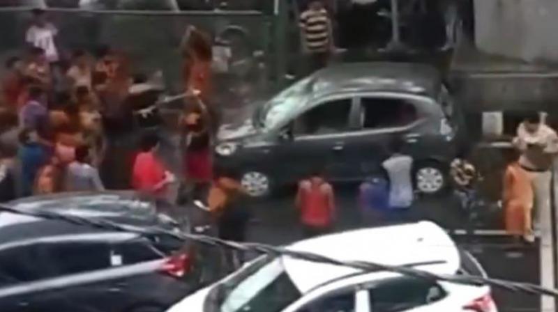Over 20 Kanwarias damaged a grey Santro car, police said. (Screengrab | ANI)