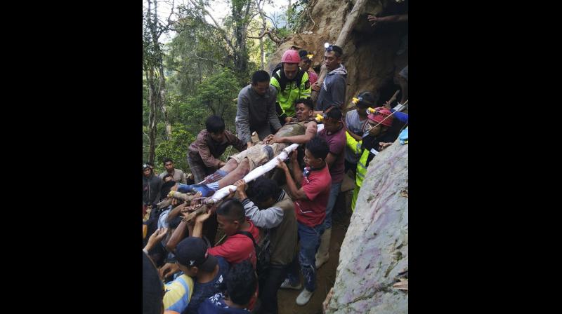 Indonesian officials said on Wednesday dozens of rescuers were using spades and ropes to dig out more than 60 people. (Photo:AP)