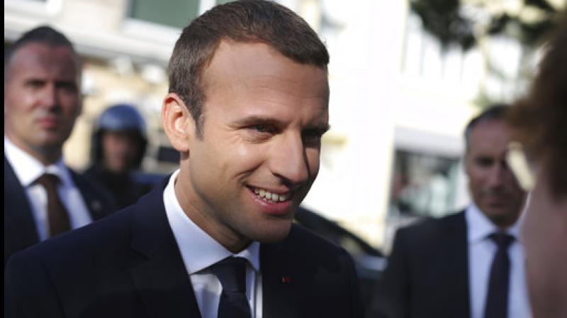 French President Emmanuel Macron meets peoples he leaves his house before voting in the final round of parliamentary elections, in the northern seaside town of Le Touquet, France. (Photo: AP)