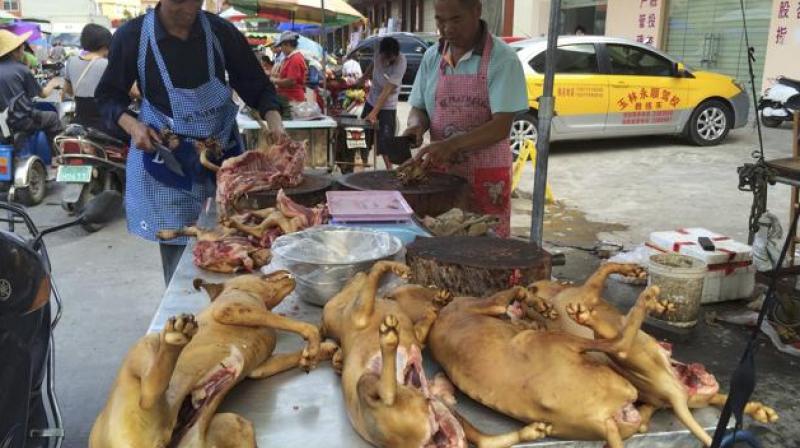 Vendors chop dog meat for sale at a market ahead of a dog meat festival in Yulin. (Photo: AP)
