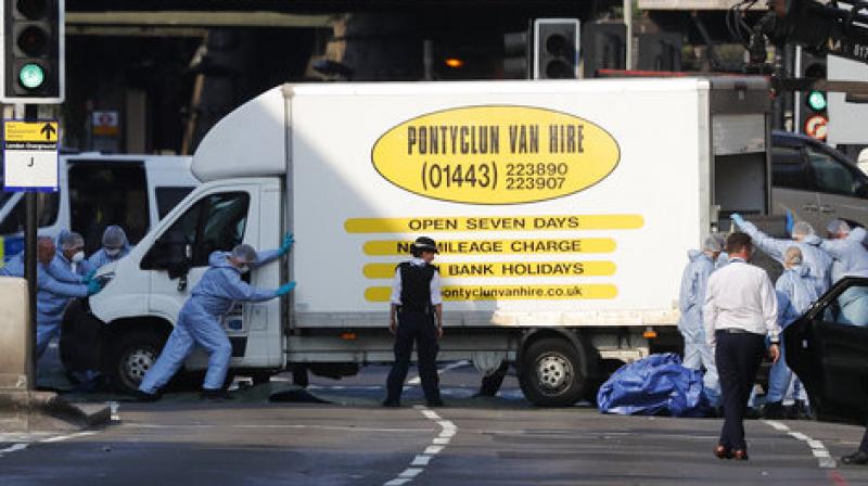 Forensic officers move the van at Finsbury Park in north London, where a vehicle struck pedestrians in north London Monday. (Photo: AP)