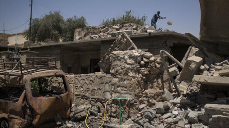 An Iraqi man removes rubble from his damaged house in a neighborhood recently retaken by Iraqi security forces during fights against Islamic State militants in Mosul, Iraq. (Photo: AP)