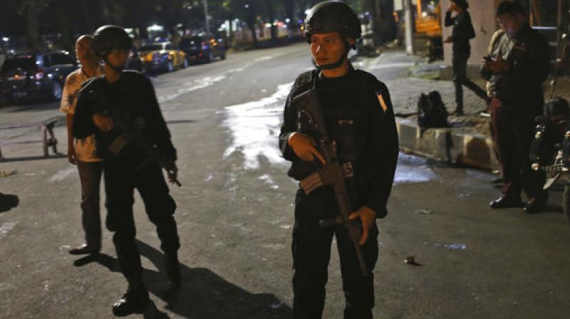 Police officers stand guard at a roadblock near the mosque where a suspected Islamic militant stabbed two policemen in Jakarta, Indonesia. (Photo: AP)