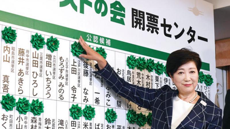 Tokyo Gov. Yuriko Koike smiles as she adds another green rosette on the name of an elected candidate of her new party, Tomin First no Kai, or Tokyoites First Party, while waiting for the result of Sundays city assembly election in Tokyo. (Photo: AP)