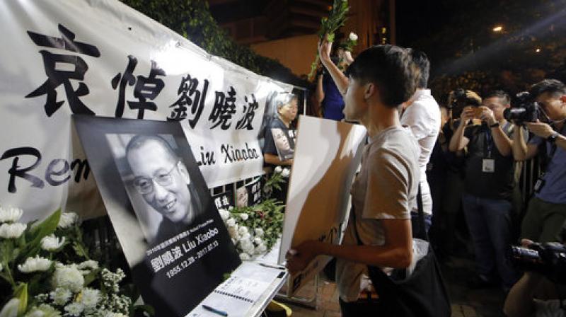 Protesters mourn jailed Chinese Nobel Peace laureate Liu Xiaobo during a demonstration outside the Chinese liaison office in Hong Kong. (Photo: AP)