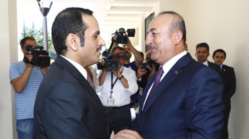 Turkeys Foreign Minister Mevlut Cavusoglu, right, shakes hands with Qatars Foreign Minister Sheikh Mohammed bin Abdulrahman Al Thani, left, prior to their meeting in Ankara. (Photo: AP)