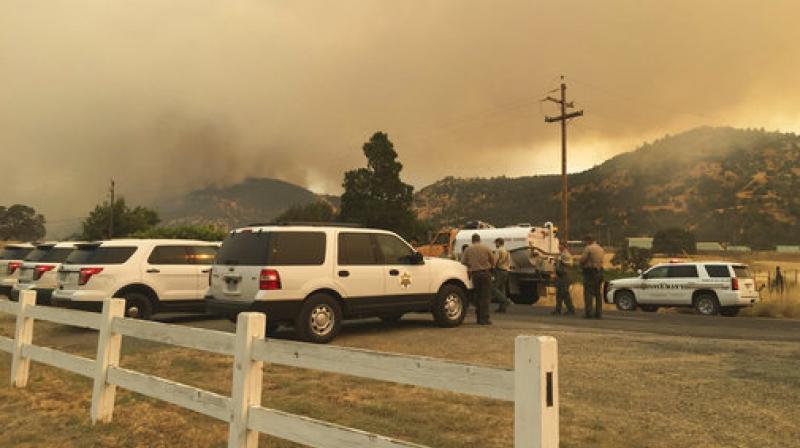 Merced and Mariposa County Sheriffs Office members gather during a wildfire in Mariposa County, California. (Photo: AP)