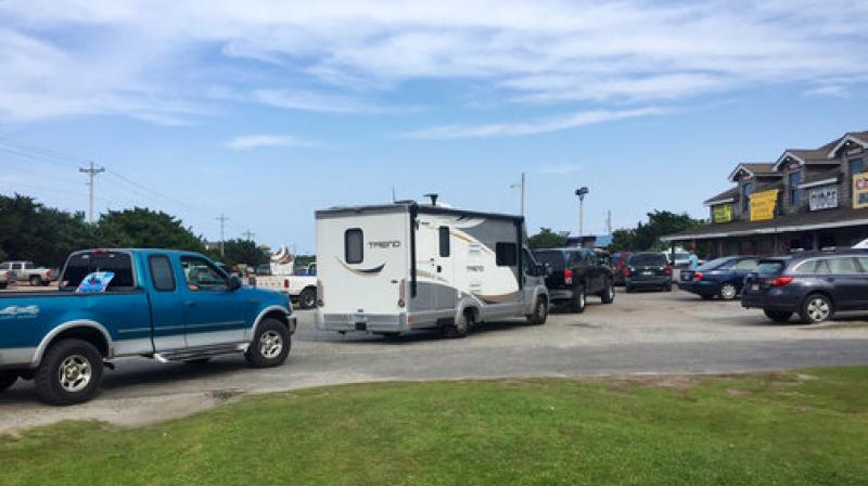 Vehicles line up at the a gas station on Ocracoke Island on North Carolinas Outer Banks, as visitors leave the island and residents fuel up. An estimated 10,000 tourists were ordered Thursday to evacuate the island after a construction company caused a power outage, leaving people stranded without air conditioning or places to eat. (Photo: AP)