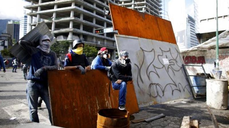 Anti-government demonstrators wait for Venezuelan Bolivarian National Guards, at a barricade in Caracas, Venezuela. (Photo: AP)