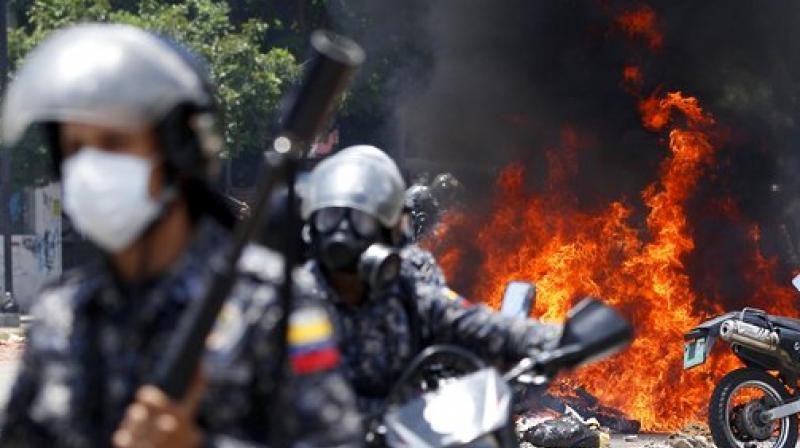 Venezuelan Bolivarian National police move away from the flames after an explosion at Altamira square during clashes against anti-government demonstrators in Caracas, Venezuela. The explosion injured several officers and damaged several of their motorcycles. The officers were then seen throwing several privately owned motorcycles into the remaining fire in reprisal. (Photo: AP)