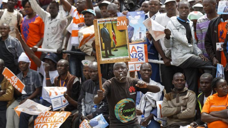 A supporter holds up a placard of opposition leader Raila Odinga at his final electoral campaign rally in Uhuru Park in downtown Nairobi, Kenya. (Photo: AP)