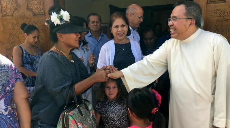 Pastor Fr. Jose Antonio Lito P. Abad, right, greets parishioners as they leave Blessed Diego de San Vitores Church following Sunday Mass in Tumon, Guam. (Photo: AP)