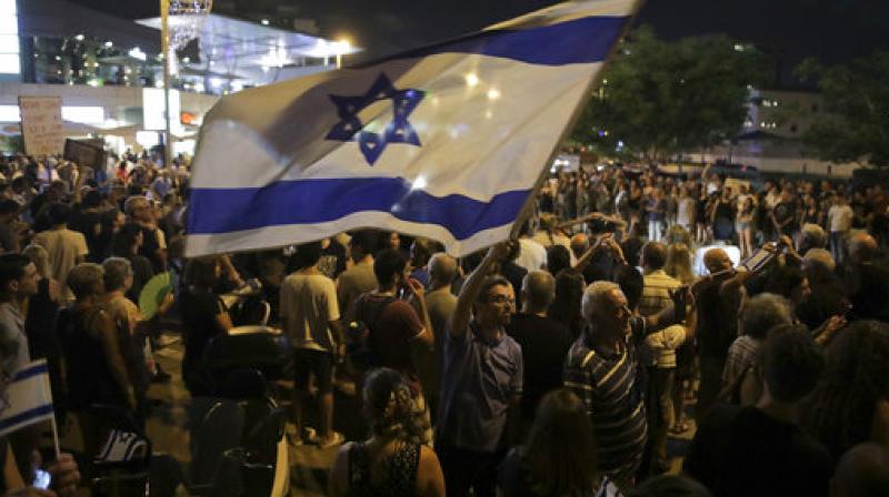 Israelis take part in a weekly protest against Israeli Prime Minister Benjamin Netanyahu, seen on the poster, in front of the home of Israels attorney general Avichai Mandelblit in Petah Tikva. (Photo: AP)