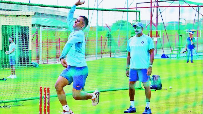 India wicketkeeper M.S. Dhoni bowls in the nets as coach Ravi Shastri looks on. (Photo: BCCI)