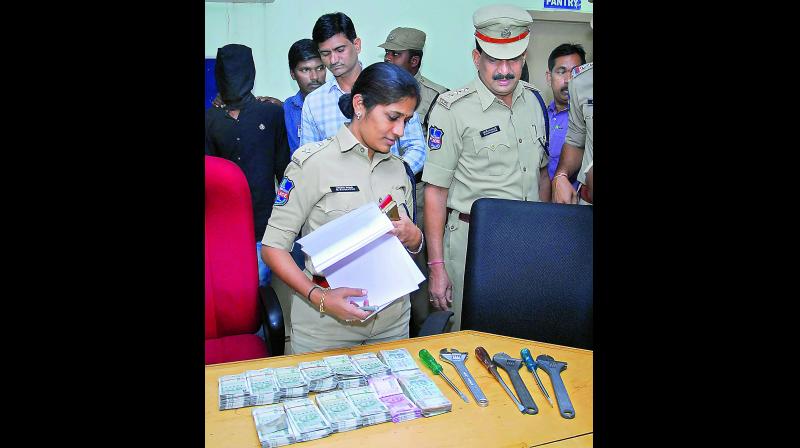 DCP B. Sumathi checks out the cash and tools seized from burglars.