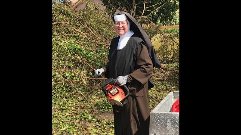 Sister Margaret Ann cutting down trees in Florida ollowing Hurricane Irma. (Photo: Facebook / Miami-Dade Police Department)