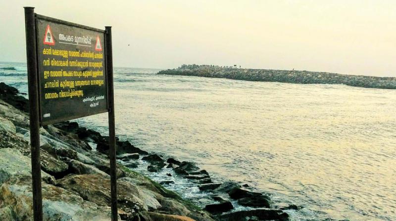 Warning board put up by harbour engineering department against fishermen going out to sea at Muthalapozhi, Perumathura.	DC