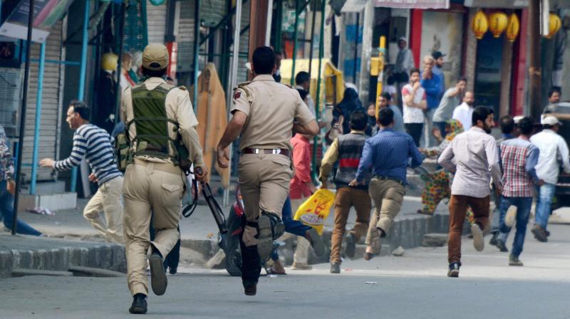 Security personnel chase away agitators during a protest against the police action on protesters in Kupwara, in Srinagar. (Photo: PTI)
