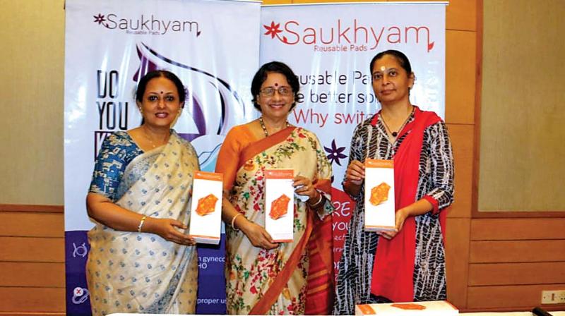 (From left to right) Deepa Santhosh, devotee of Mata Amritanandamayi Math,  Meera Krishnakutty, member of a self reliant village programme by the math and Anju Bist, co-creator of Saukhyam Reusable Pads showing the  sanitary napkins at an event organised on account of World Menstrual Hygiene Day on Monday (Photo: DC)