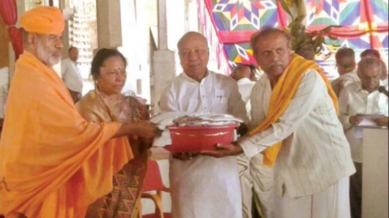 Jain pontiff Charukeethy Bhattaraka Swamiji  distributes clothes and foodgrains to people at Shravanabelagola on Saturday 	 DC