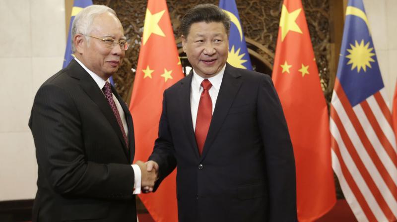 Malaysian Prime Minister Najib Razak, left, poses with Chinese President Xi Jinping for a photo prior to their meeting at Diaoyutai state guesthouse in Beijing. (Photo: AP)