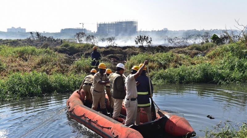 Firefighters inspect Bellandur lake, which has become so toxic that it spontaneously catches fire, and emits clouds of white froth. (Photo: PTI/File)