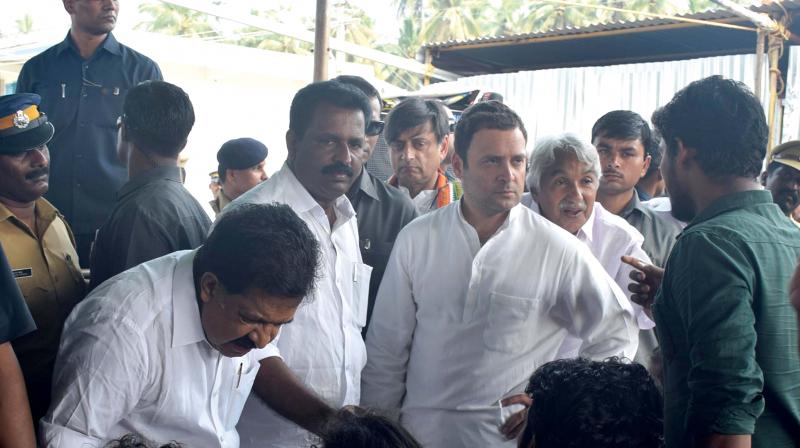 Rahul Gandhi listens to John Paul Xavier in Vizhinjam on Thursday.