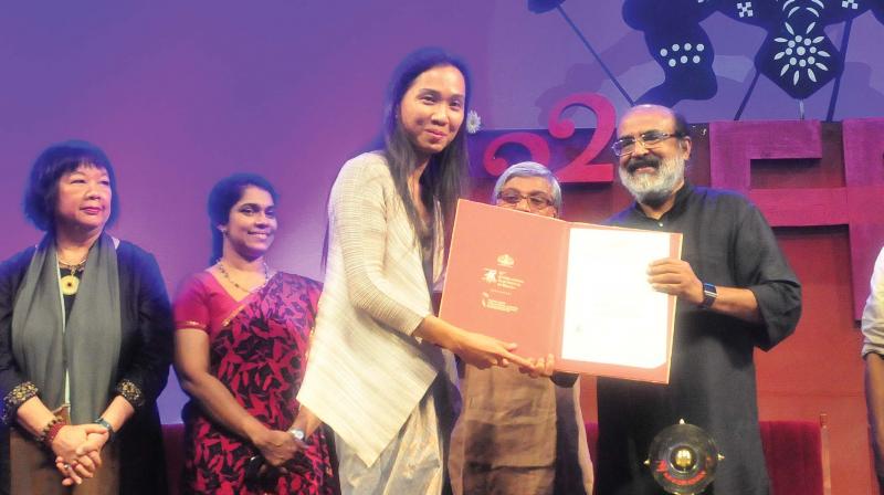 Anucha Boonyawatana receives Rajatha Chakoram for Best Director from Finance Minister T.M. Thomas Isaac at 22th International Festival of Kerala in Thiruvananthapuram on Friday. (Photo: A.V. MUZAFAR)