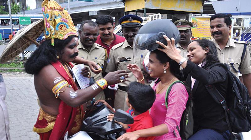 Mahabali takes part in the traffic awareness campaign of the traffic cops in Kochi telling a woman two-wheeler driver who was riding the scooter without a helmet, about the virtue of wearing helmets at Edappally Junction in Kochi. 	DC FILE PIC