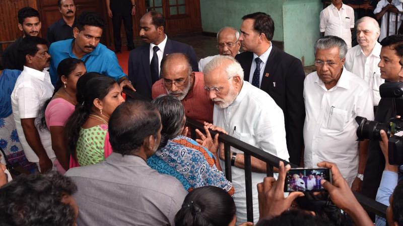 Prime Minister Narendra Modi listens to the woes of fisherfolk at Poonthura in Thiruvananthapuram on Tuesday.