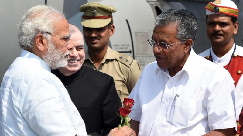 Chief Minister Pinarayi Vijayan welcomes Prime Minister Narendra Modi. Govenor P. Sathasivam looks on.