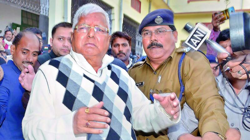 RJD supremo Lalu Yadav escorted by police after being convicted by the special CBI court in the fodder scam case, in Ranchi, on Saturday. 	(Photo: PTI)