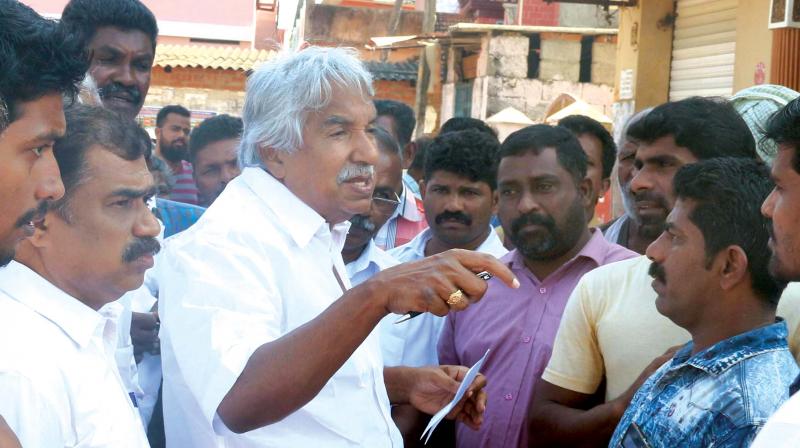 Former Chief Minister Oommen Chandy with fishermen at Poonthura on Saturday.   (Photo: G. G. Abhijith)