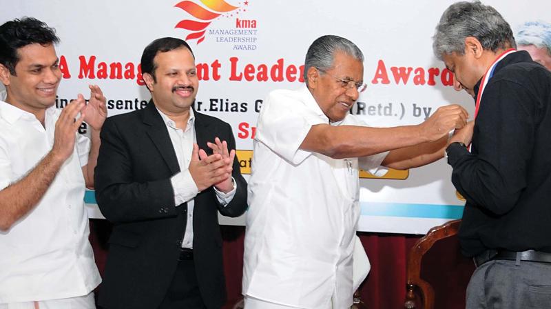 Chief minister Pinarayi Vijayan presents the Management Leadership award 2017 to former KMRL MD Elias Gorge in Kochi on Thursday. Hibi Eden MLA  and KMA president Vivek Krishna Govind are also seen. (Photo: ARUN CHANDRABOSE)