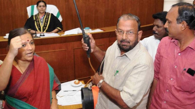 Opposition leader in the council K.J. Antony sprays anti-mosquito chemical near the mayors chair during the corporation council meeting in protest against civic bodys failure in tackling mosquito menace. 	(Photo: ARUN CHANDRABOSE)