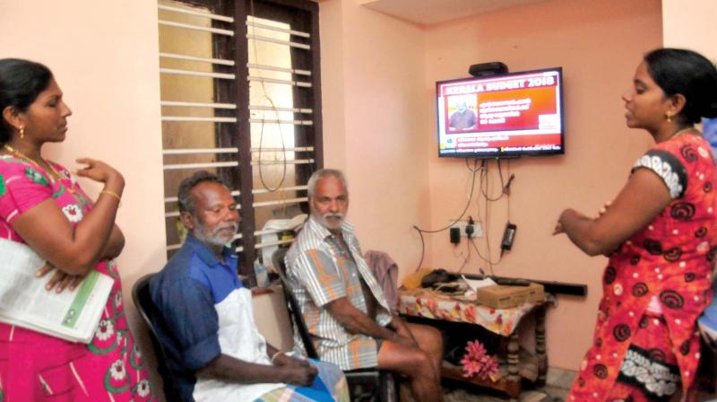 S Joseph, one of the fishermen from Poonthura and a survivor of Ockhi, watches the budget speech at the home of his friend Pushpanayakam. Neighbours Shani and Shirly help him understand the speech. (Photo: A.V. MUZAFAR )