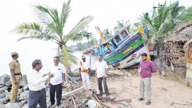 A. Annadurai, Thanjavur district collector, looking at a damaged boat after the cyclone at Sethubavachathiram.