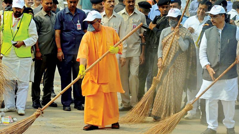 UP Chief Minister Yogi Adityanath wields a broom as he takes part in a cleanliness drive at the Taj Mahal in Agra on Thursday   (Photo: PTI )