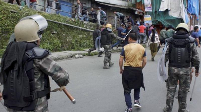 Security personnel chase away GJM supporters who were staging a protest meeting in Darjeeling on Tuesday over West Bengal governments decision to teach Bengali in all schools. (Photo: PTI)