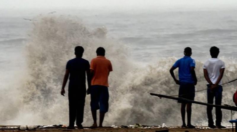 People watch the waves breaking at the coast at Marina Beach after the Cyclone Vardah on the coast of the Bay of Bengal in Chennai. (Photo: PTI)