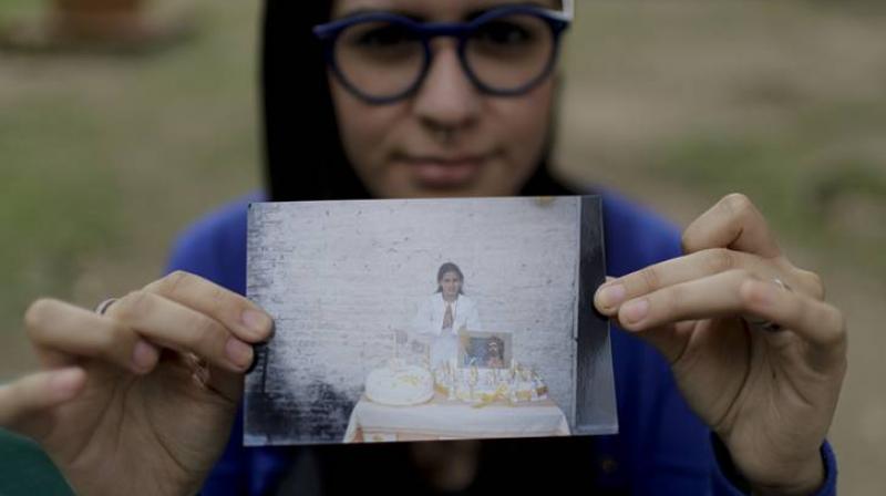 Karen Maydana shows a picture of herself as a child celebrating her first Holy Communion in Caseros. (Photo: AP)