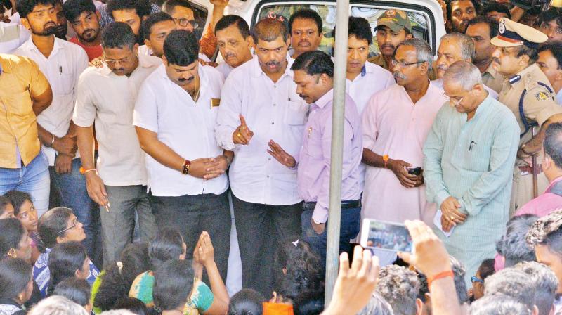 Deputy Commissioner Sasikanth Senthil speaks with the family members of Deepak Rao at their residence in Katipalla near Surathkal on Thursday. (Right) The crowd at Deepaks house after his body was brought  from the hospital 	 KPN