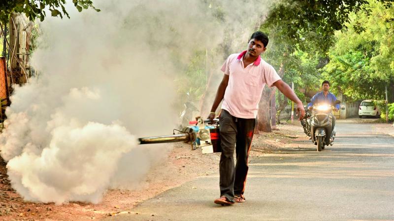 Watchman of the AP Text Book Colony doing fogging for mosquitoes with the hand-held fogging machine purchased by the colony residents.