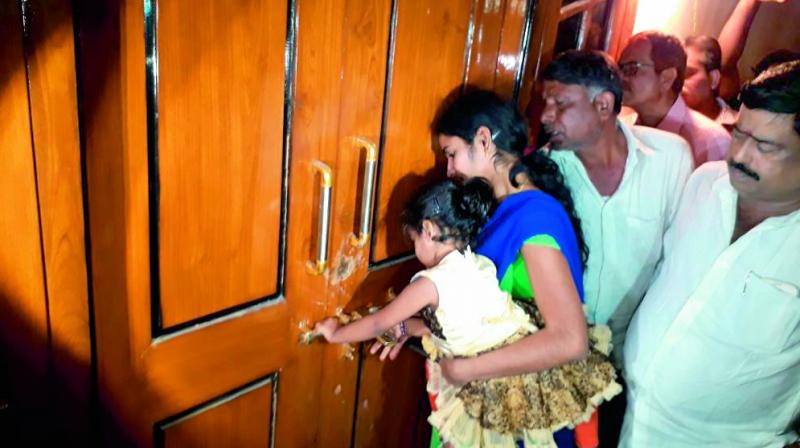 TRS leader Srinivas Reddys wife Sangeetha Reddy along with her daughter opens the door of the house after a city court passed an order in her favour. (Photo: DC)