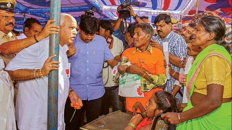 BJP state president B.S. Yeddyurappa talks to women during a public meeting at Sira in Tumakuru district on Thursday 	KPN