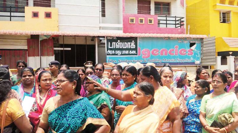 Women protest outside the Tasmac shop situated in a residential complex in Siva Sakthi Nagar, Annanur.