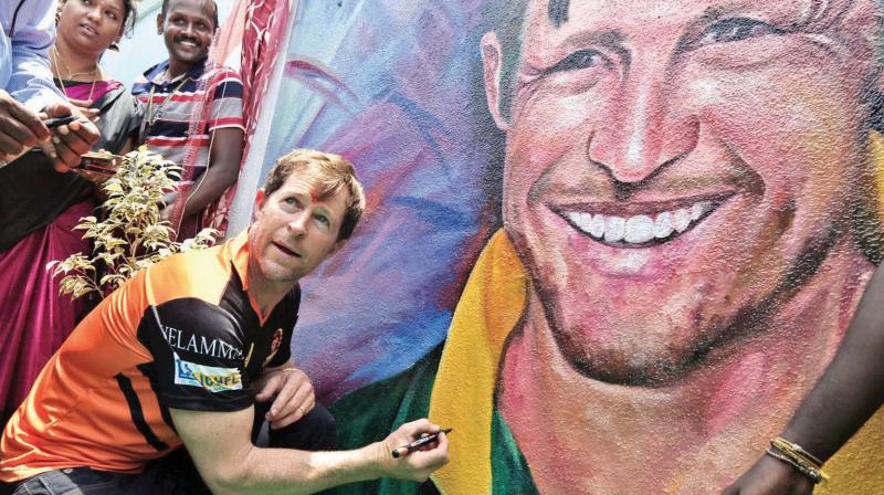 Jonty Rhodes signs an autograph on a painting during his visit to a Chennai school. (Photo: DC)